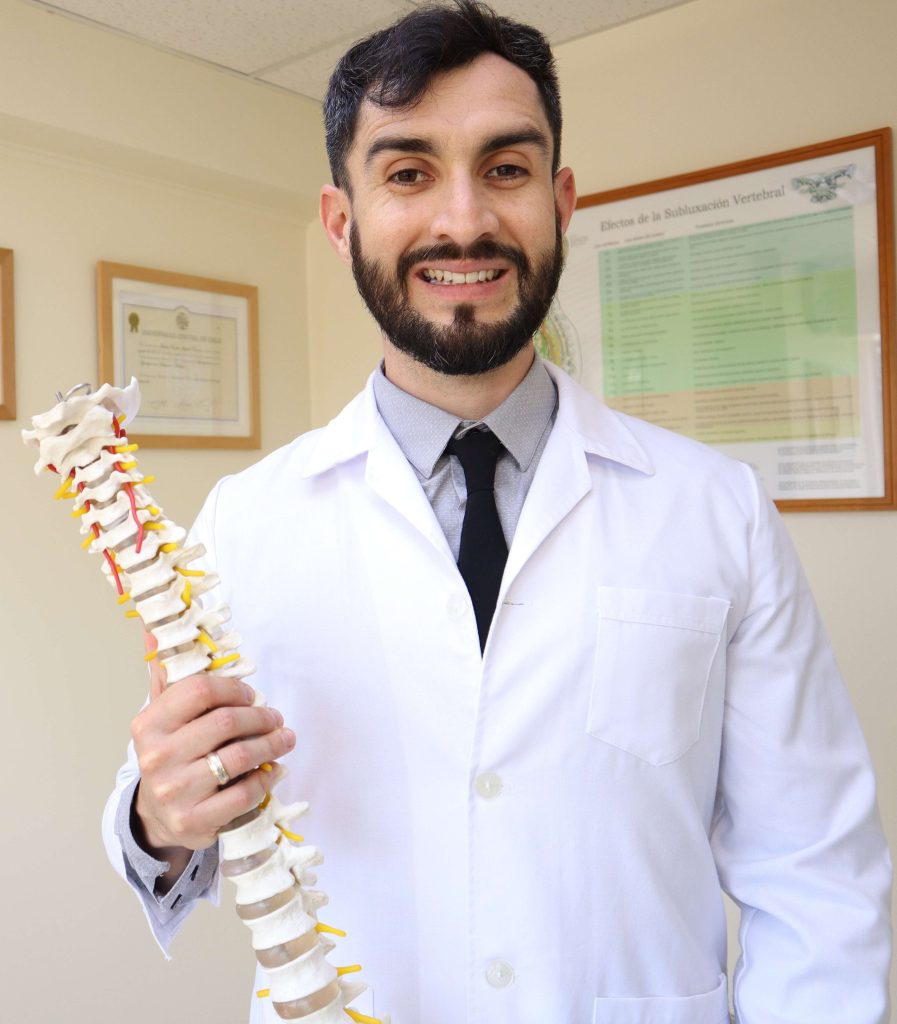 Matías aguilar, quiropráctico en Viña del Mar, fundador de Be Active, sosteniendo la representación de una columna vertebral