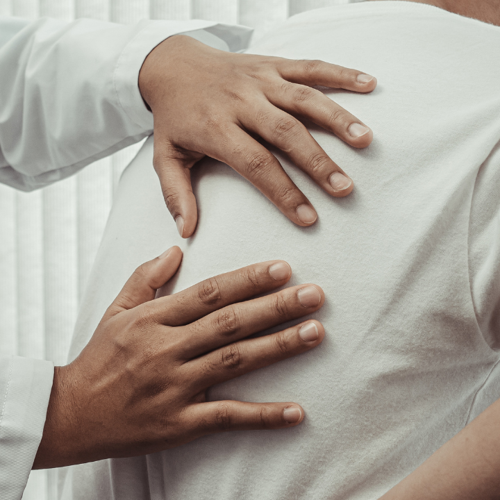 Un quiropractico realizando un ajuste en la espalda alta de un paciente